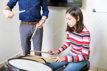 Schlagzeuglehrer unterrichtet einen Schüler am Drumset